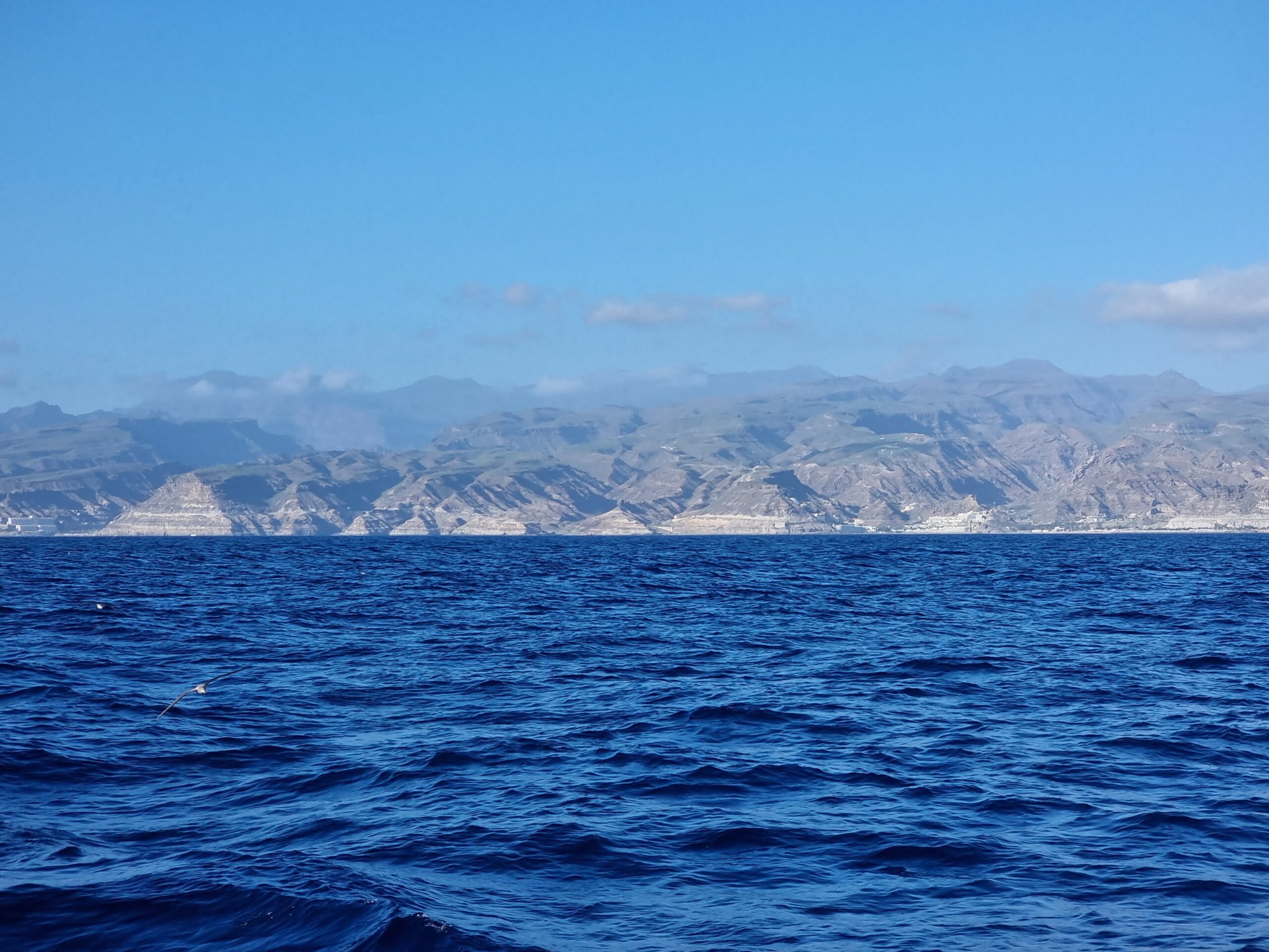 Deep blue sea with mountains on the horizon