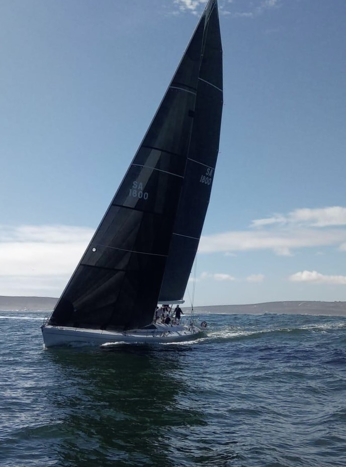 Warrior with a blue spinnaker and crew on deck