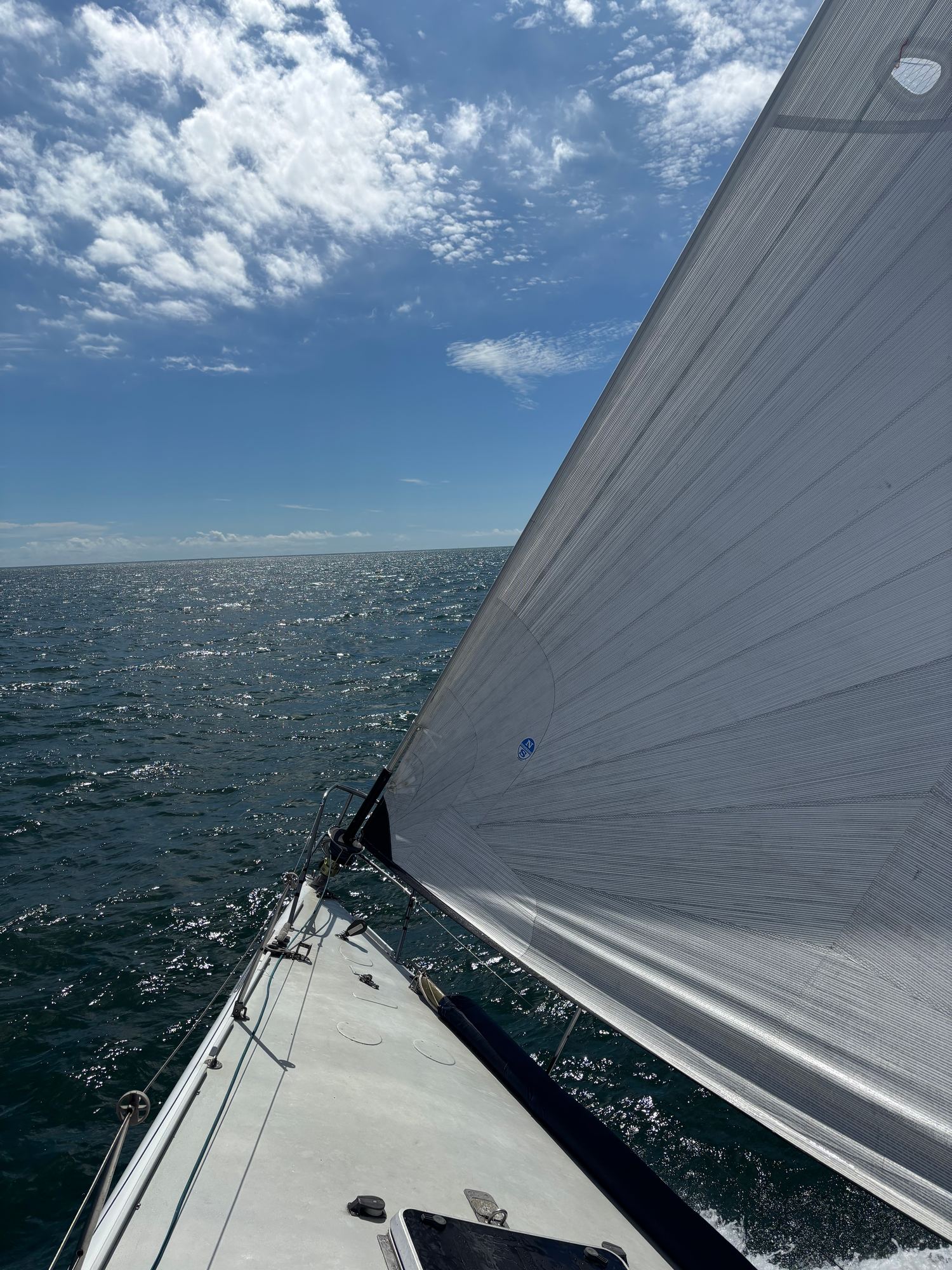 The jib and bow cutting through blue water
