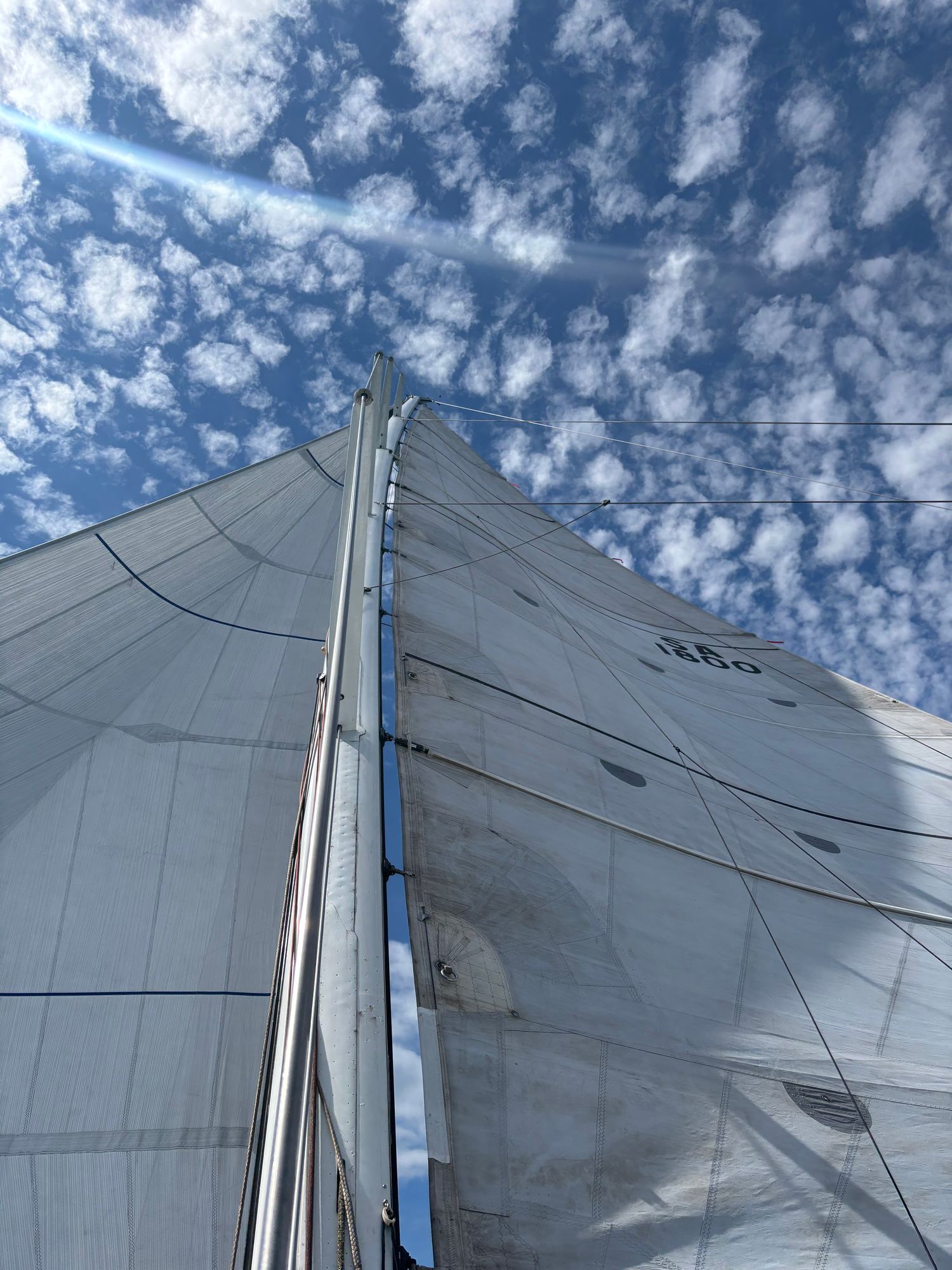 The mainsail against a sky of small clouds