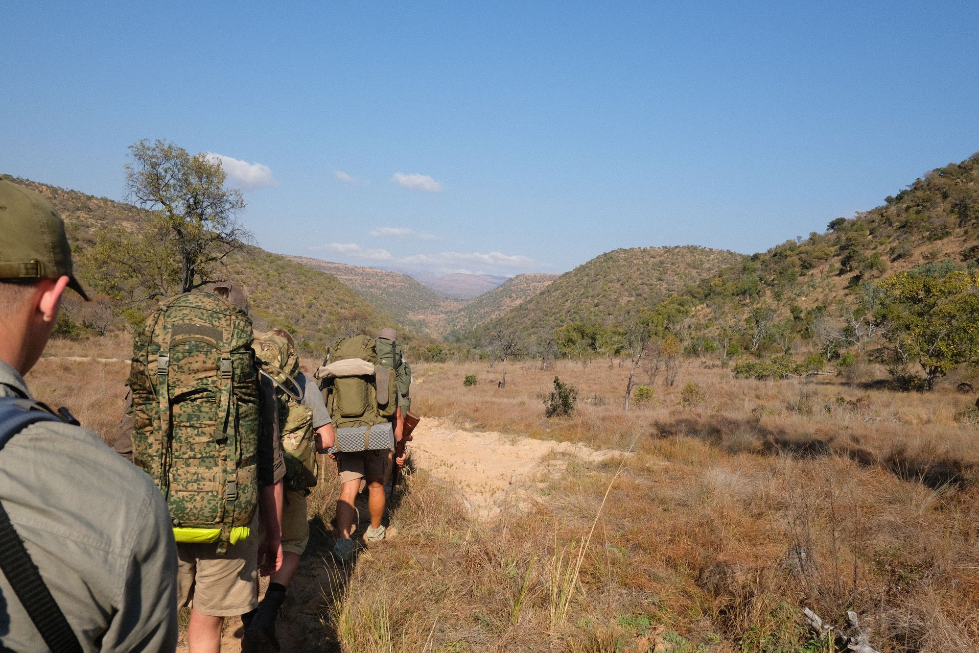 Walkers with packs heading along a dry riverbed
