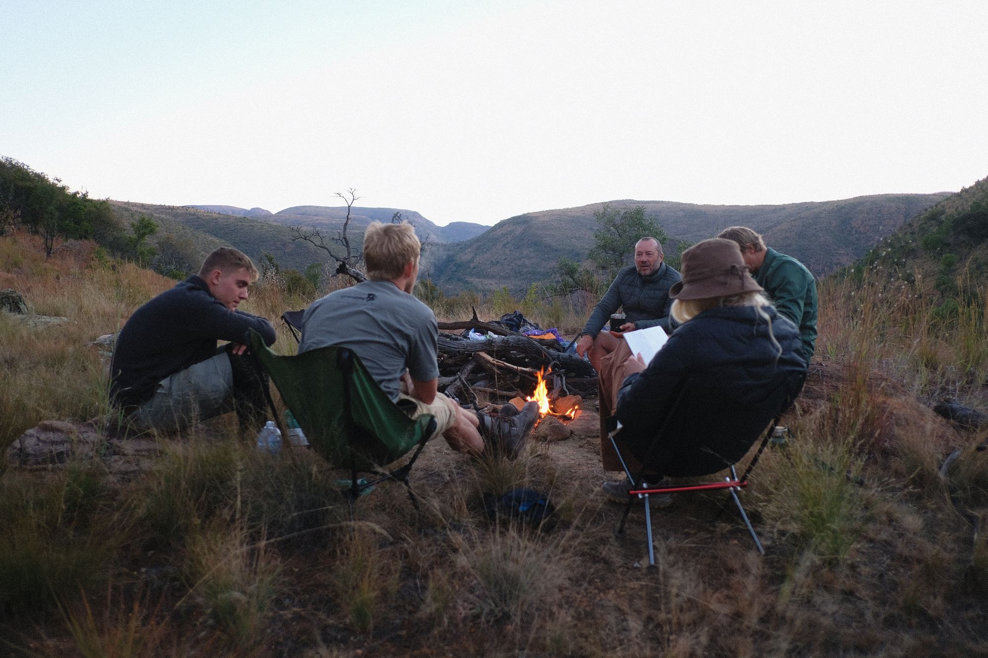A campfire circle above the valley at dusk